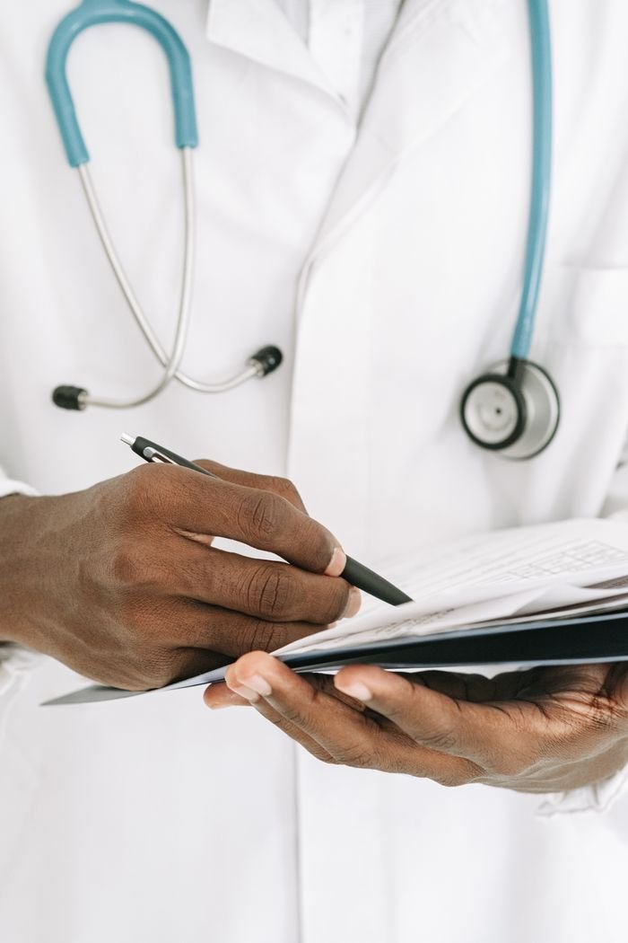 Crafting Captivating Headlines: Your awesome post title goes here Close-up of a doctor writing on a notepad, wearing a stethoscope around the neck.